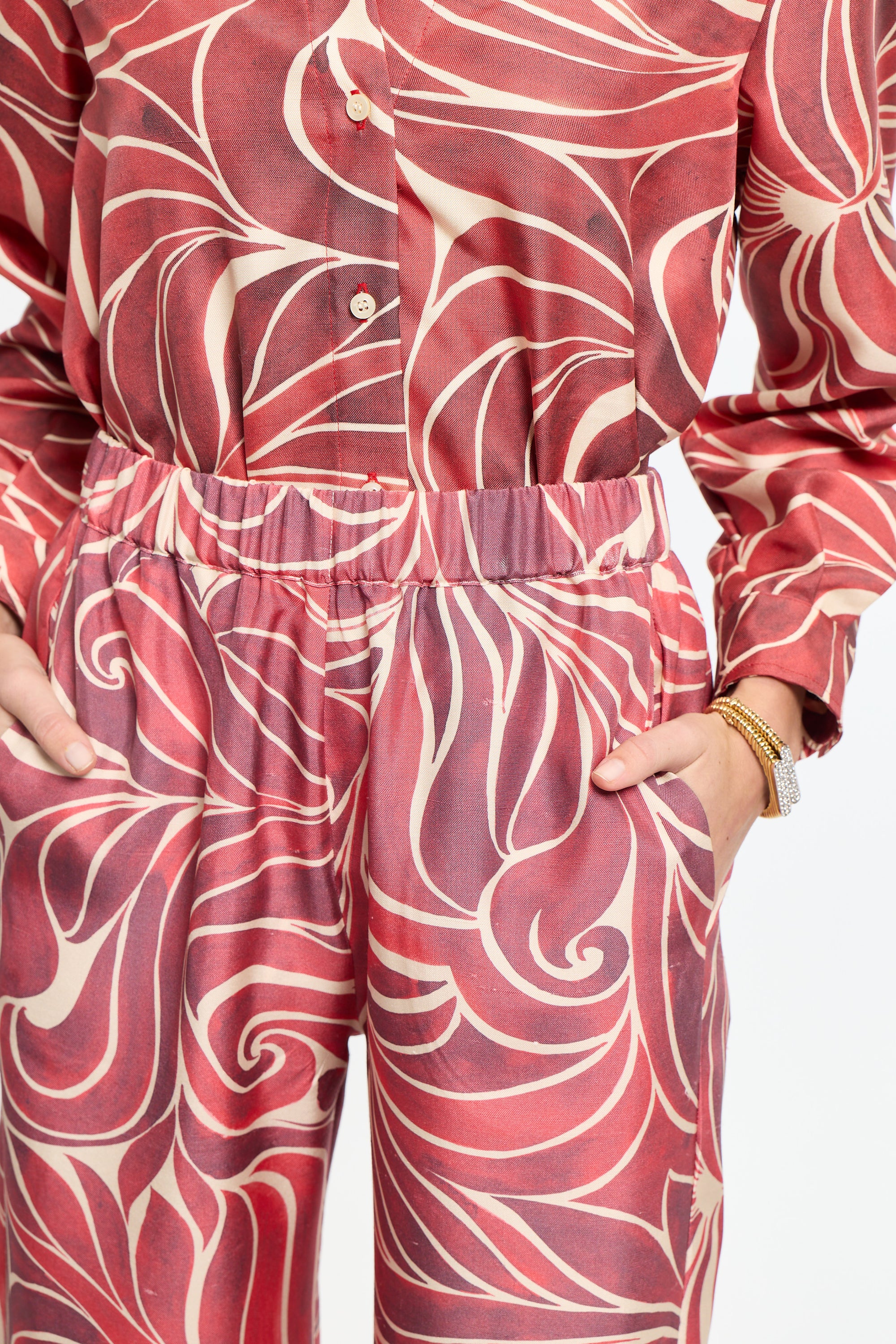 Red and white patterned shirt and pants set on a plain background