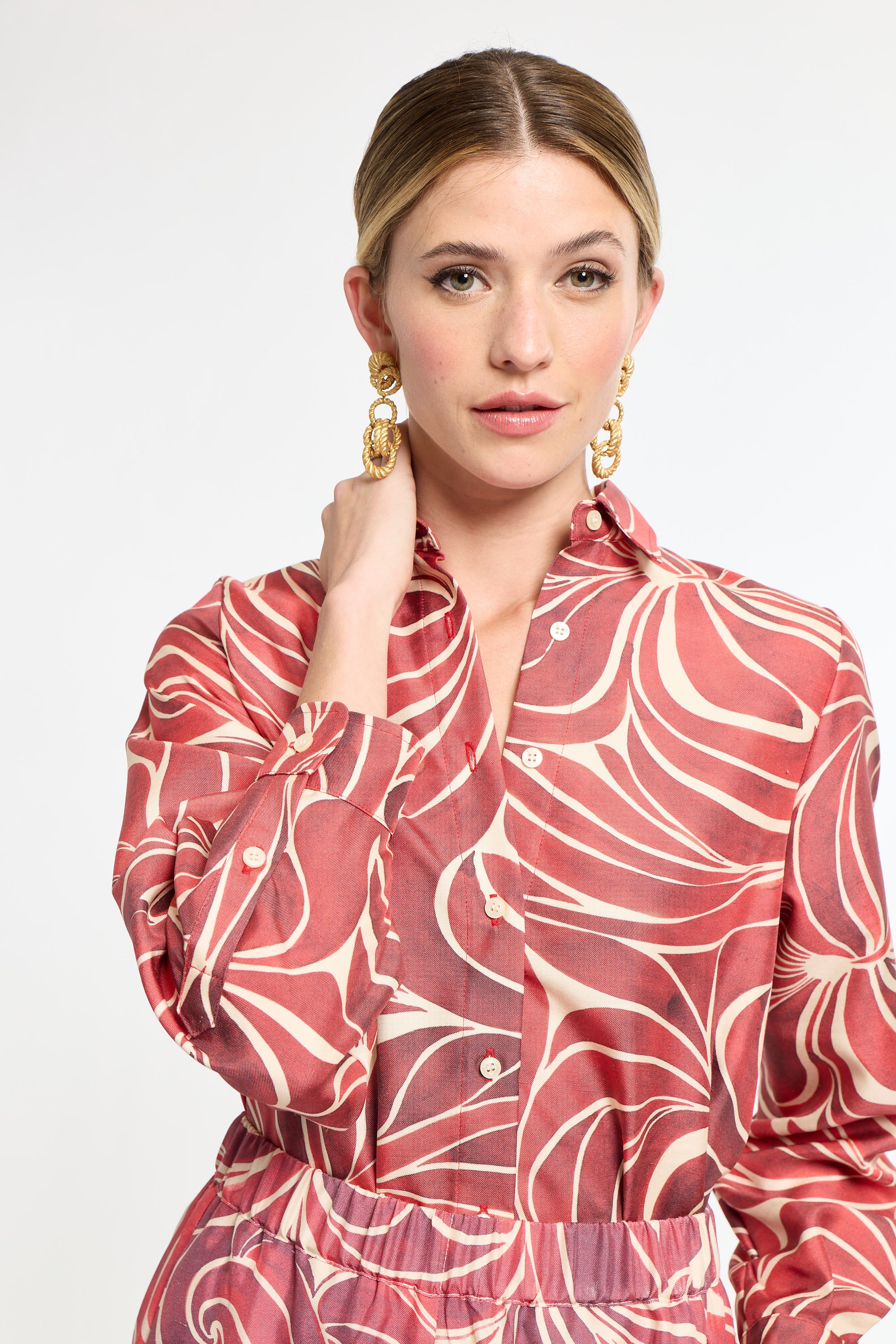 Woman wearing a red and white patterned dress on a white background