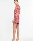 Woman wearing a red patterned shorts and dress on a white background