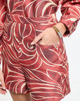 Person wearing a red and white patterned outfit with a white background