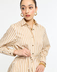Woman wearing a beige and white striped dress on a white background