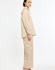 Woman wearing a beige and white striped suit on a white background