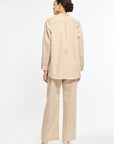 Woman wearing a beige and white striped suit on a white background