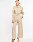 Woman wearing a beige and white striped jumpsuit on a white background