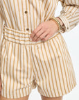 Person wearing a beige and white striped romper on a white background