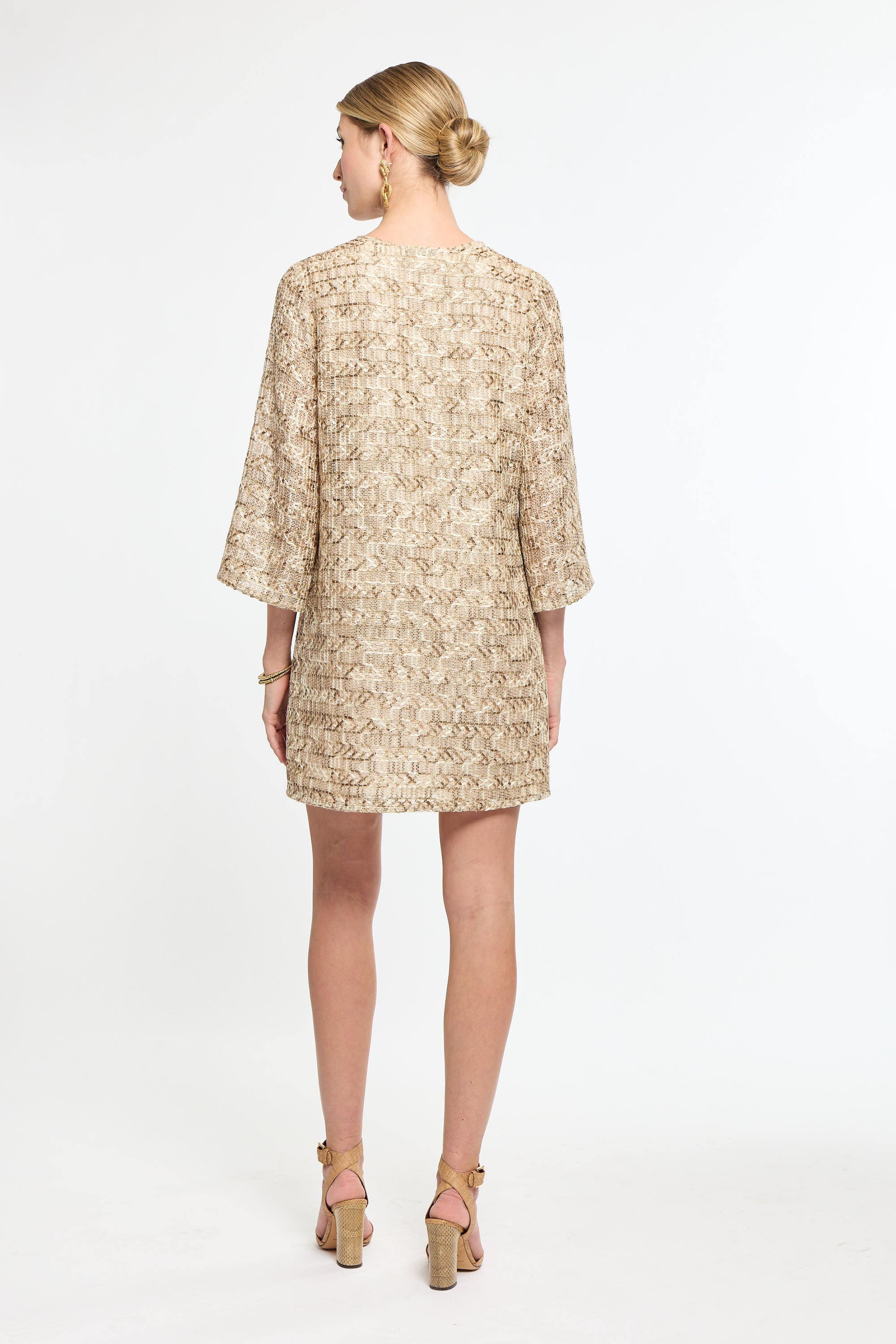 Woman wearing a beige floral dress on a white background