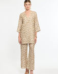 Woman wearing a beige floral outfit on a white background