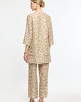 Woman wearing a beige floral outfit on a white background