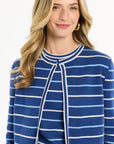 Woman wearing a blue and white striped cardigan on a white background