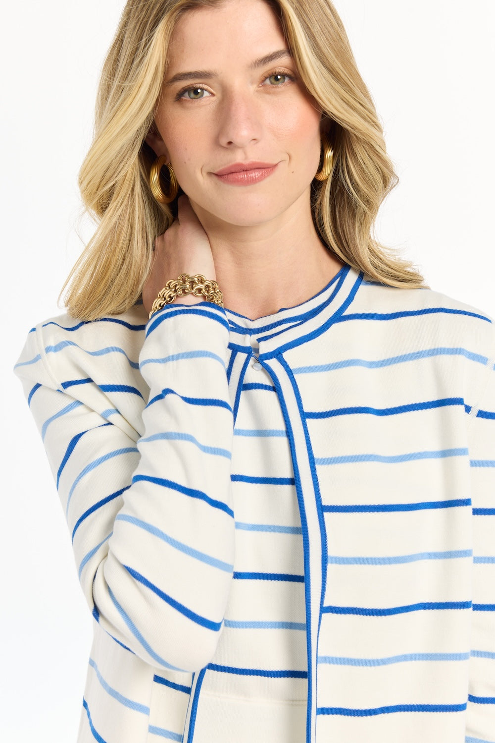 Woman wearing a blue and white striped blouse with a plain background