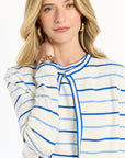 Woman wearing a blue and white striped blouse with a plain background