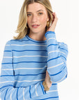 Model styled in blue stripes, photographed on a crisp white background.
