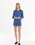 Woman wearing a dark blue and white striped outfit on a white background