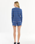 Woman showcasing a classic blue-and-white striped look, photographed in a bright studio setting.