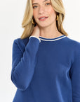 Close-up of a woman wearing a blue long-sleeve top and shorts on a white background