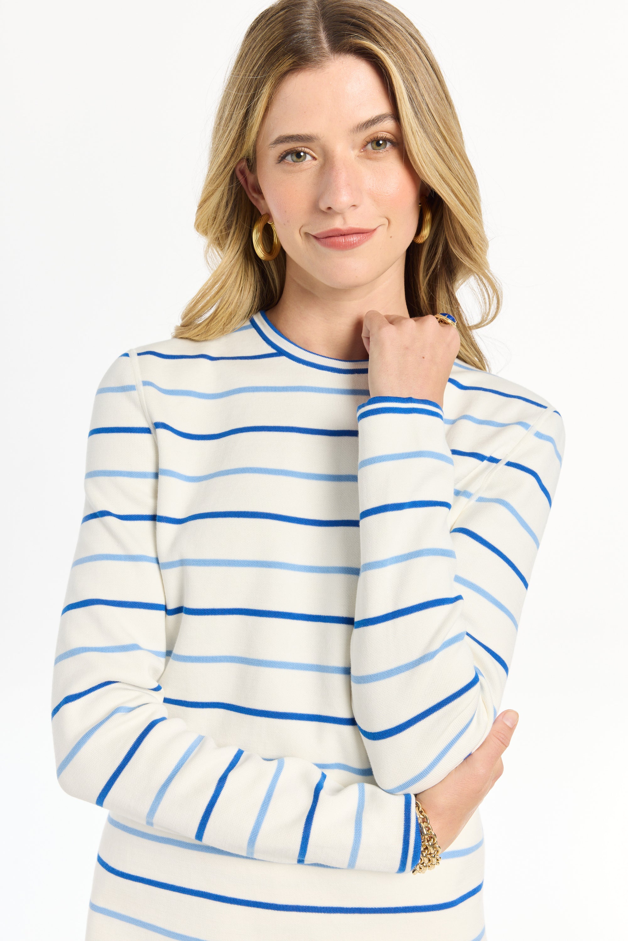 Woman wearing a striped long-sleeve top paired with matching shorts against a white backdrop.

