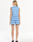 Woman wearing a blue and white striped top and short set on a white background