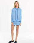 Woman wearing a blue cardigan in front of a white background