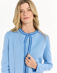 Closeup of a woman wearing a light blue outfit with a white background