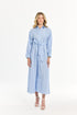 Woman wearing a light blue striped dress with a belt on a white background