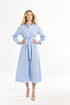 Woman wearing a light blue dress with a belt on a white background