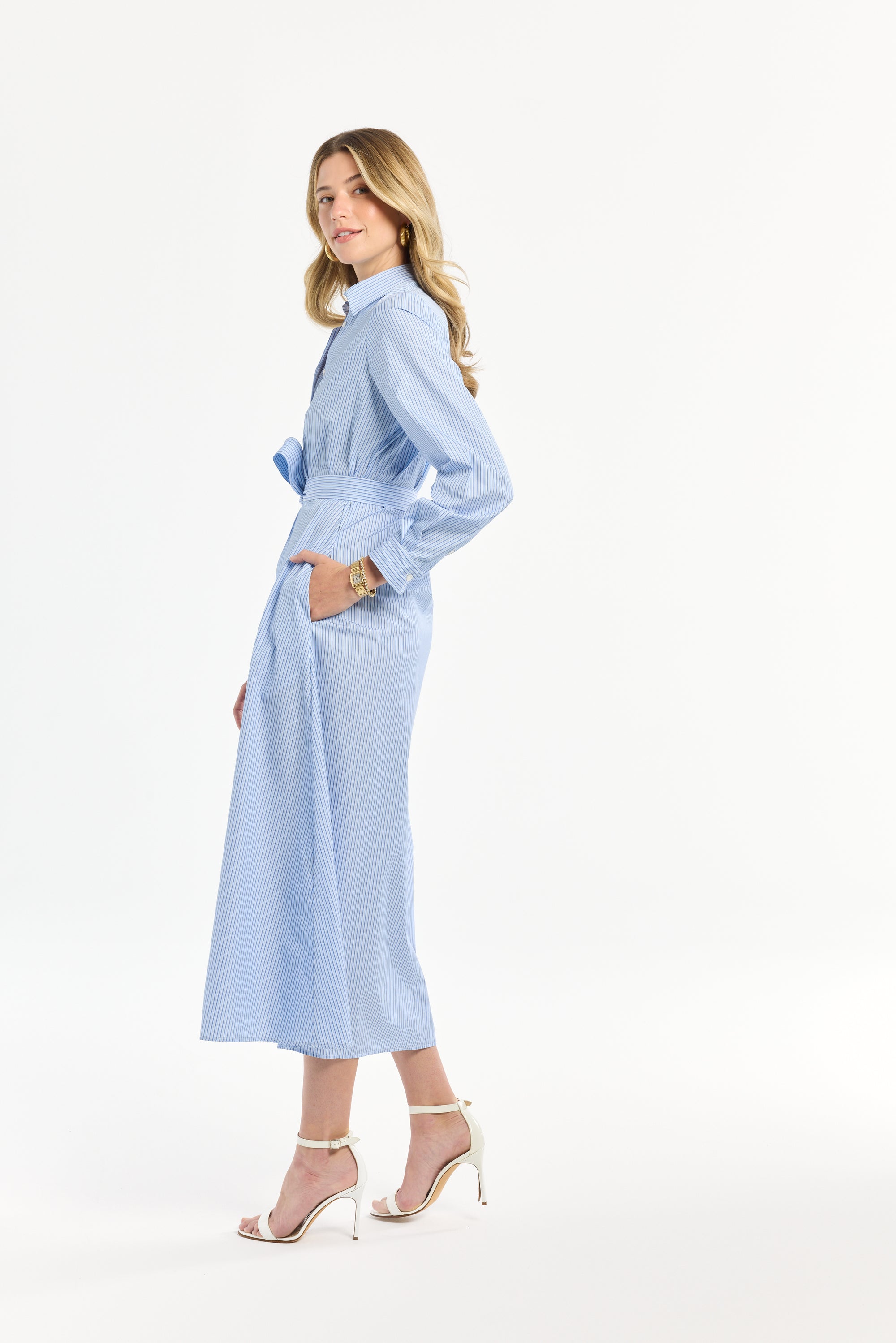 Woman wearing a light blue striped dress on a white background
