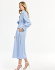 Woman wearing a light blue striped dress on a white background