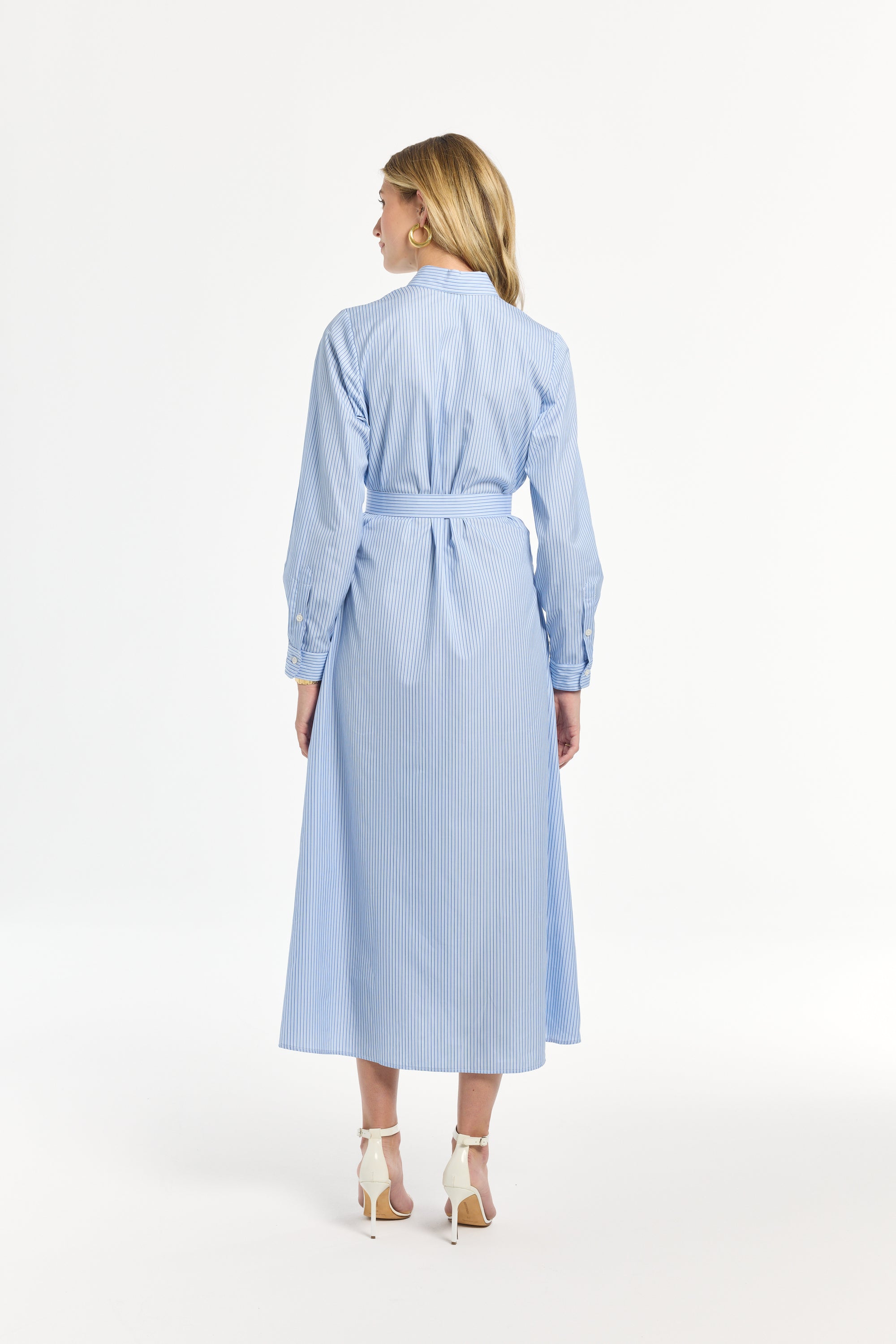 Woman modeling a light blue dress striped on a white background