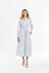 Woman wearing a blue and white striped dress with a belt on a white background