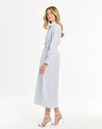 Woman wearing a light blue and white striped maxi length dress on a white background