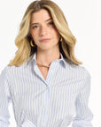 Woman wearing a light blue striped dress on a white background