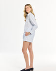 Woman wearing a light blue striped blouse and matching shorts on a white background