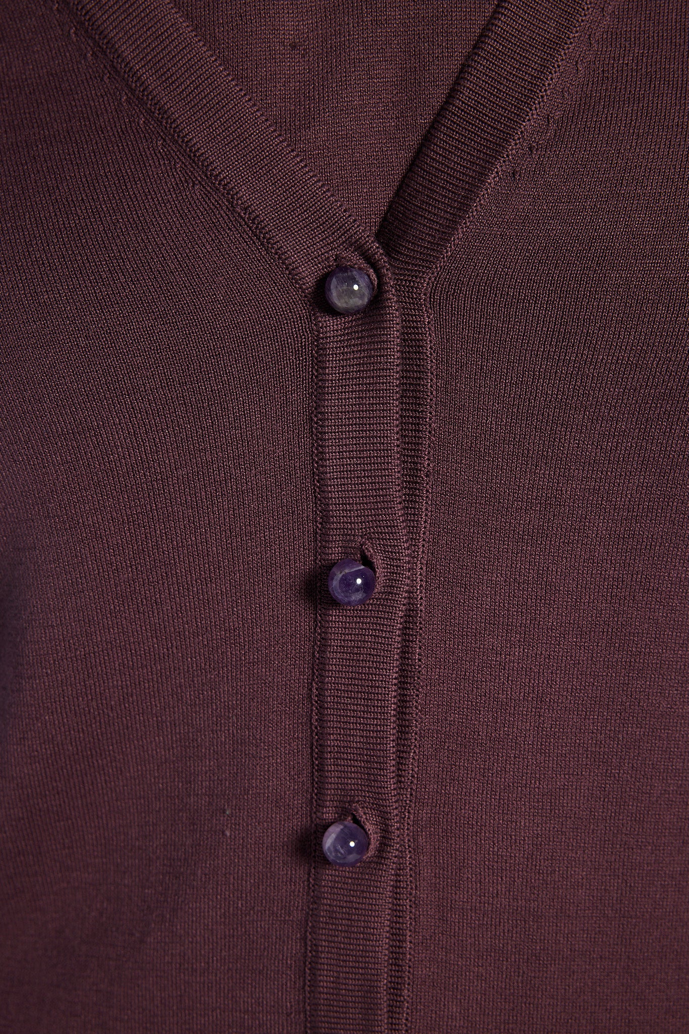 Close-up of a purple cardigan with gemstone buttons 