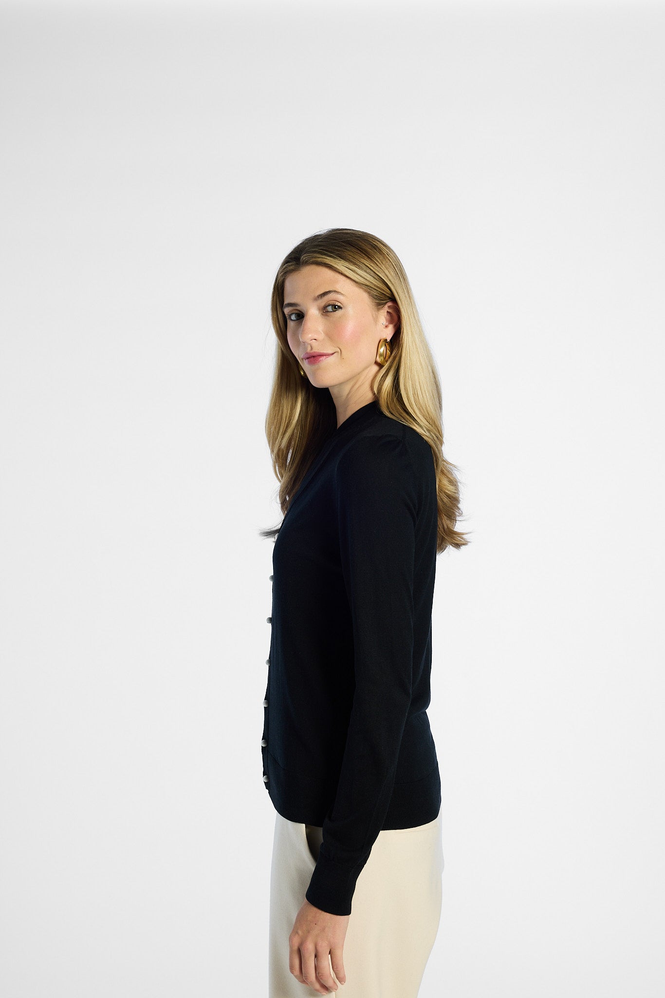 Woman wearing a black silk cardigan on a white background