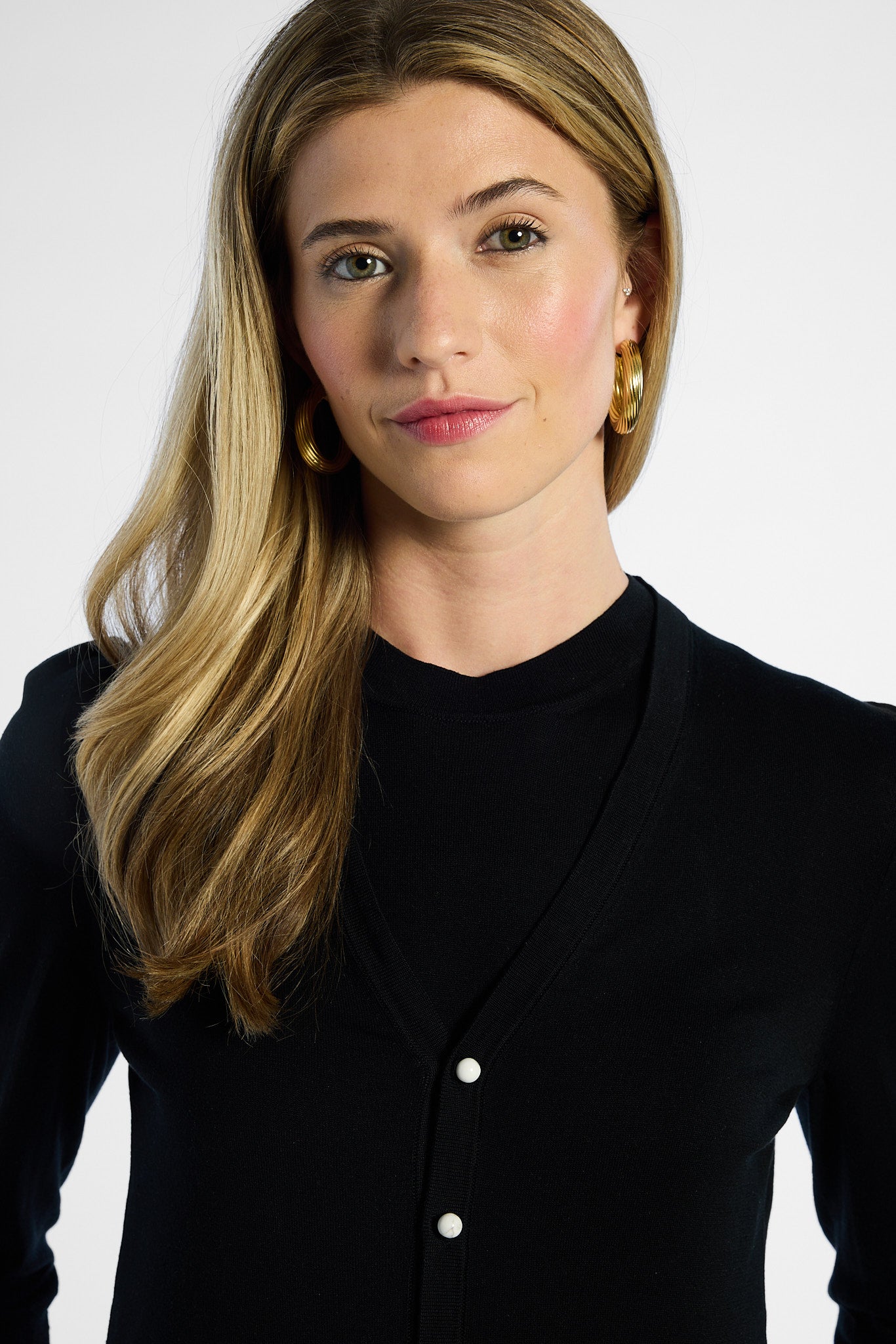 Woman wearing a black silk cardigan with a white background