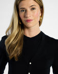 Woman wearing a black silk cardigan with a white background