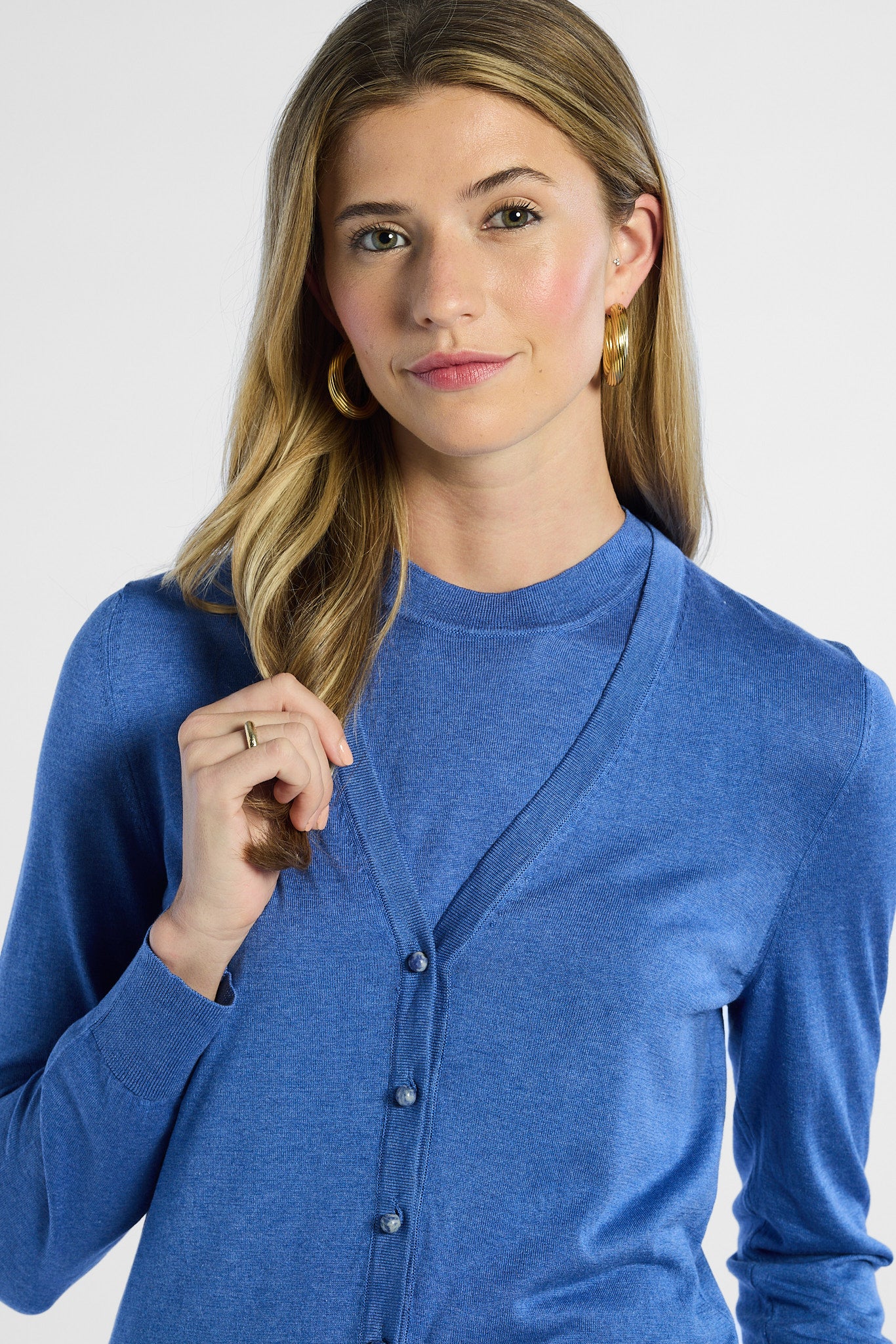 Woman wearing a blue cardigan against a white background
