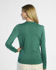 back profile of a woman wearing a green silk cardigan on a white background