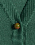 Close-up of a green silk cardigan with unakite gemstone buttons 