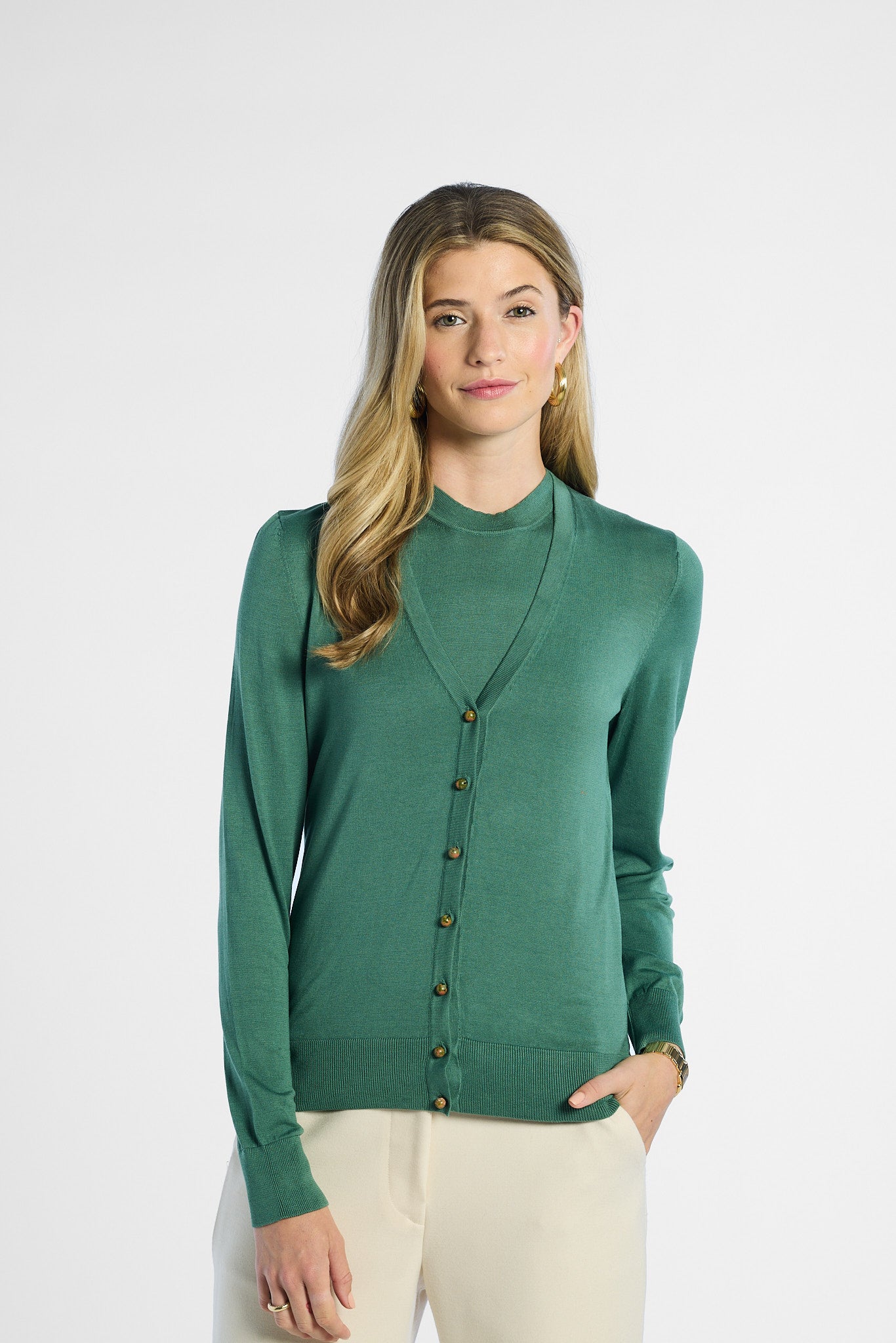Woman wearing a green silk cardigan on a white background