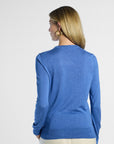 back profile of a woman wearing a blue sweater against a white background