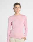 Woman wearing a pink silk crewneck on a white background