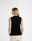 Woman wearing a black sleeveless top and beige pants on a white background