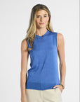 Woman wearing a blue sleeveless silk top against a white background