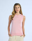 Woman wearing a pink sleeveless silk top against a light blue background