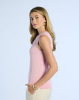 Woman wearing a pink sleeveless silk top against a light blue background