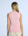 Woman wearing a pink sleeveless silk top against a light blue background