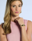 Woman wearing a pink sleeveless silk top with a plain background