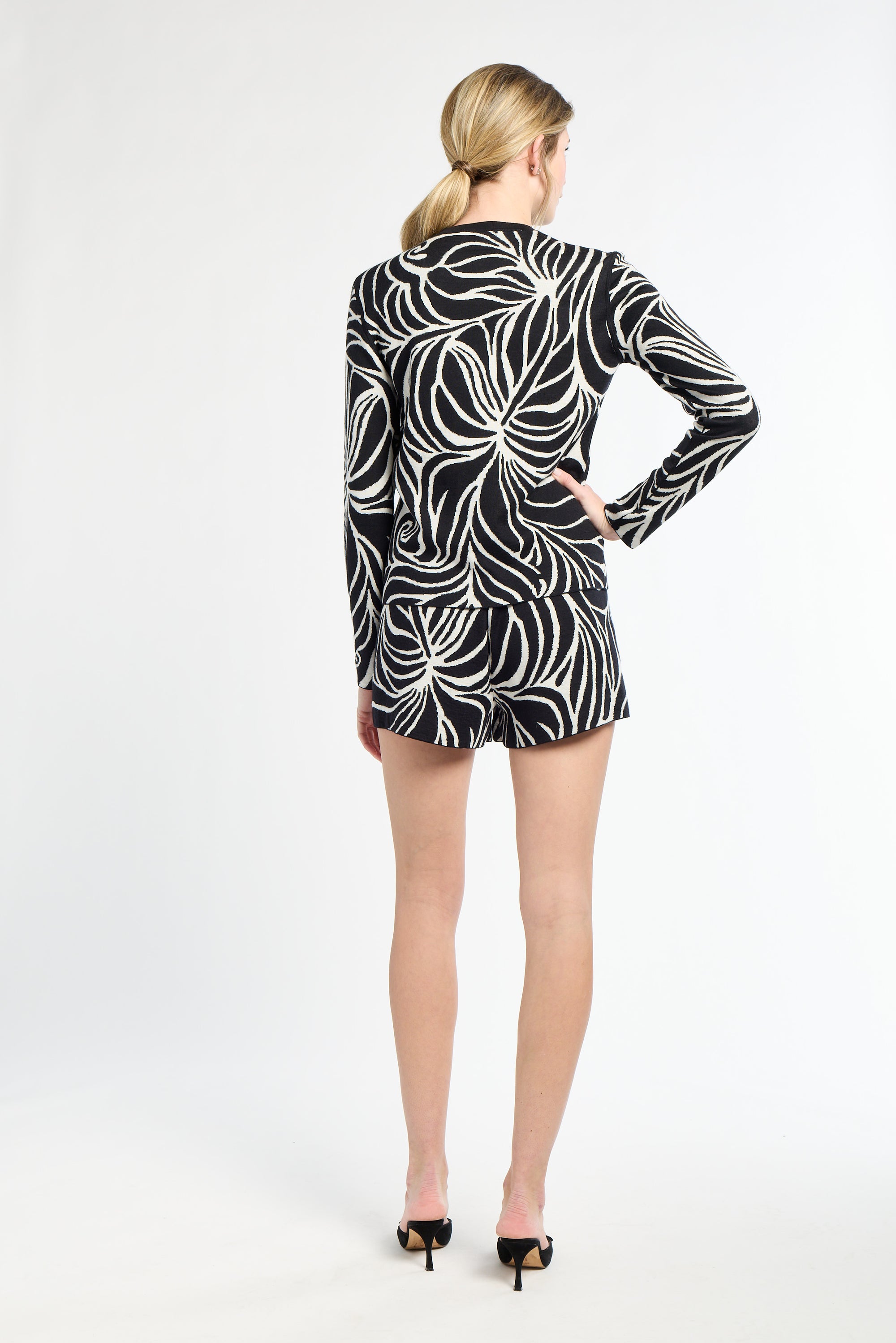 Woman wearing a black and white patterned dress on a white background
