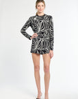 Woman wearing a black and white patterned dress on a white background